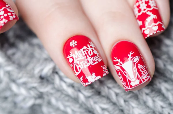 Красный Рождественский маникюр с оленями и снежинками — стоковое фото