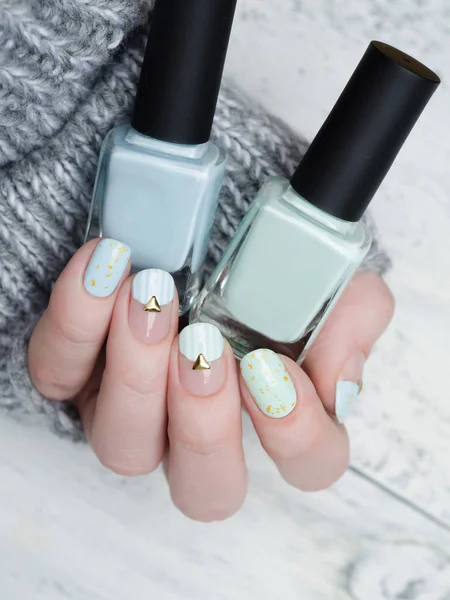 Gentle mint blue manicure with gold glitter and rivets and stripes pattern — 图库照片