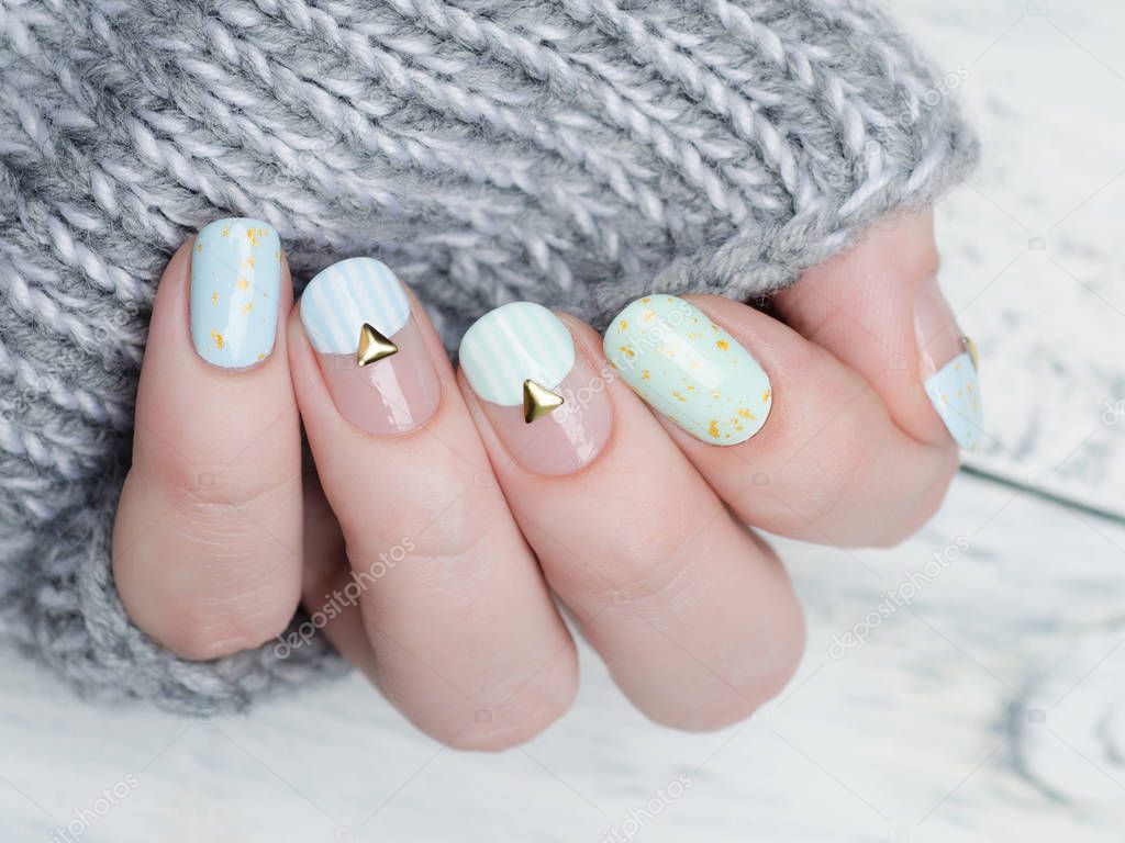 gentle mint blue manicure with gold glitter and rivets and stripes pattern