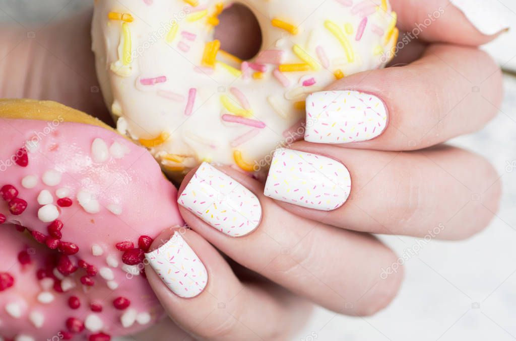 white pattern manicure with a pink donut