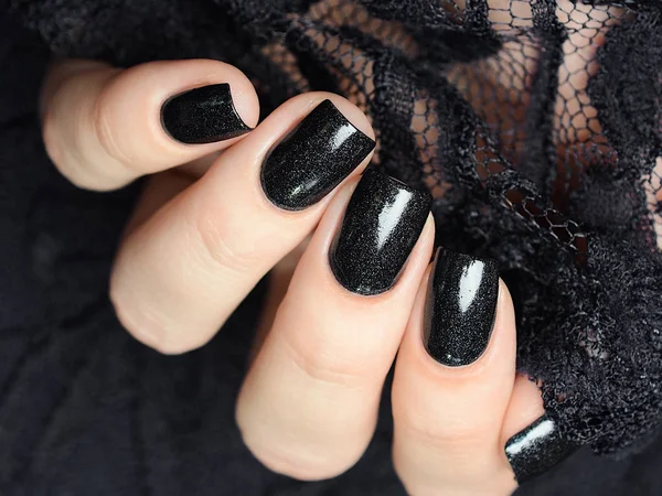 Dark blue manicure on a background of black lace — 图库照片