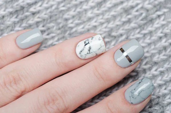 Maniküre aus weißgrauem Marmor mit silbernem Streifen auf grauem Hintergrund — Stockfoto