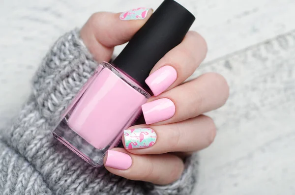 Pink manicure with pink flamingo pattern with gray sweater