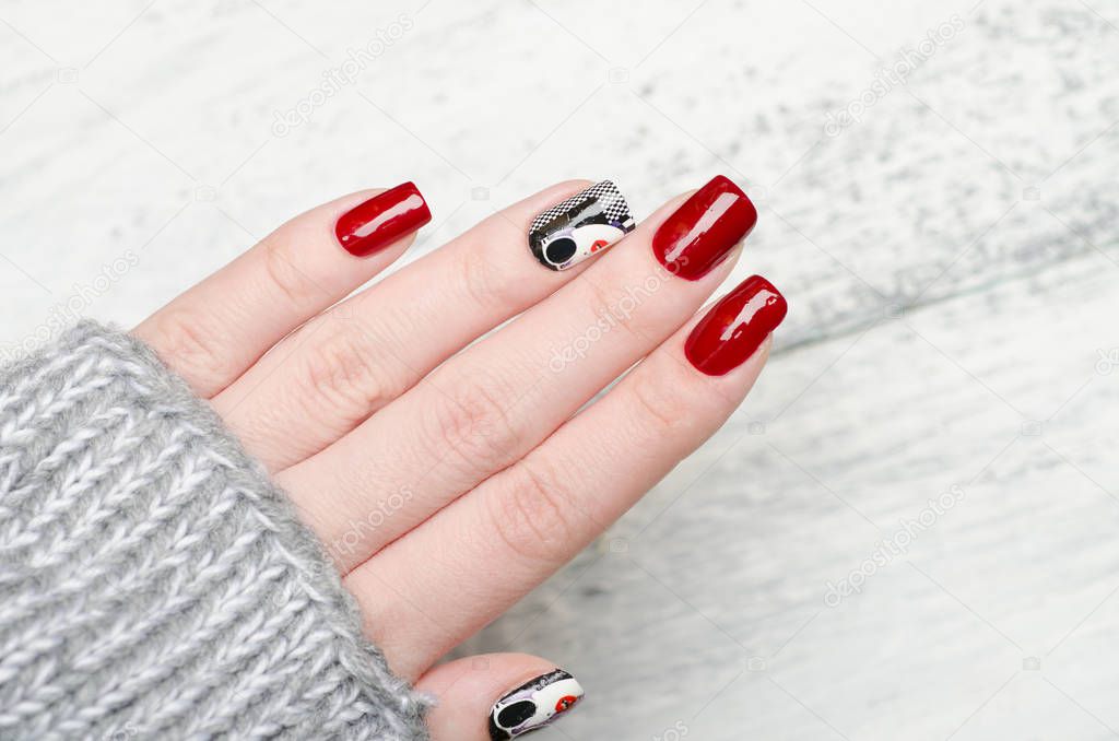 red manicure in the style of pop art with a black white woman with red lips on checkered background