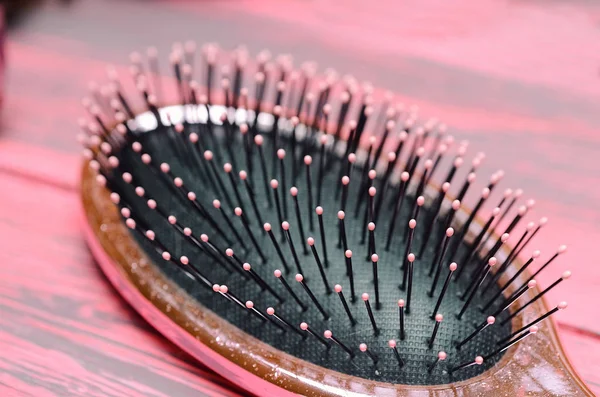 Pink hairbrush close up on a pink wooden background — Stock Photo, Image