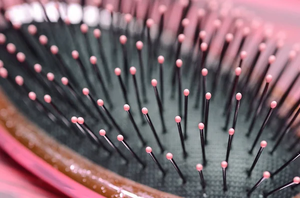 Pink hairbrush close up on a pink wooden background — 스톡 사진