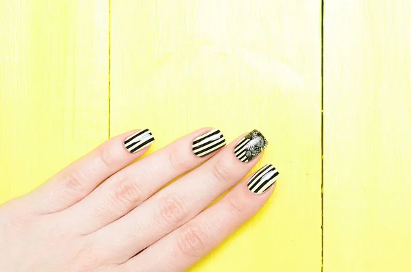 Bright yellow manicure with black stripes and sunflowers pattern on yellow background — Stock Photo, Image