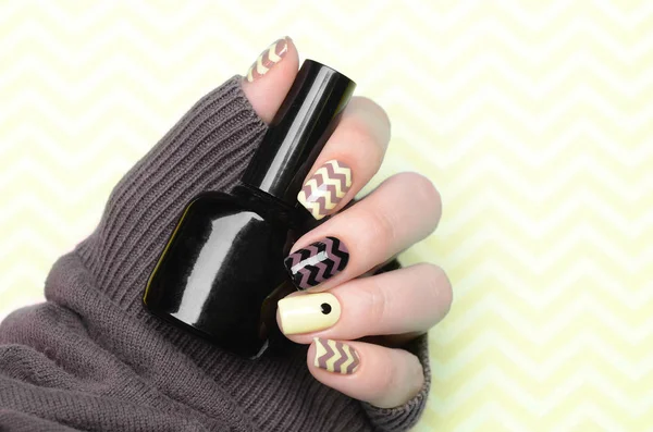 Yellow manicure with zigzag and a dot pattern on yellow background — 스톡 사진