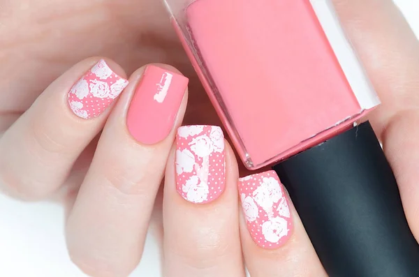 Pink manicure with a white floral print — Stock Photo, Image