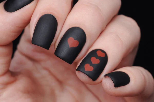 Czarny manicure na St Walentynki z czerwonym wzorem serca — Zdjęcie stockowe