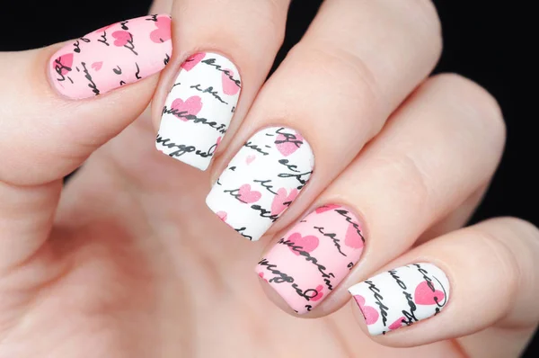 Pink white manicure on St. Valentine s Day with pattern words letter and hearts 스톡 사진