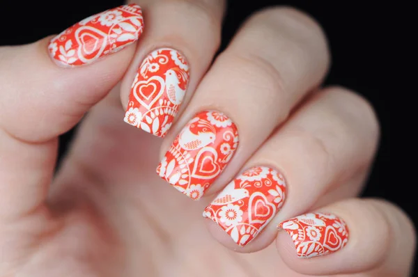 Red manicure on St. Valentine s Day with white heart pattern 스톡 사진