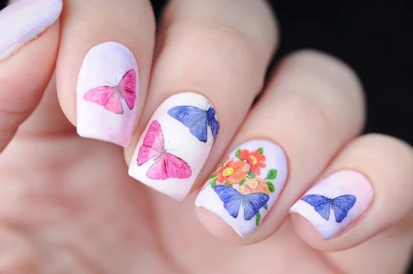 Manicura de color rosa azul con estampado de mariposa Fotos De Stock