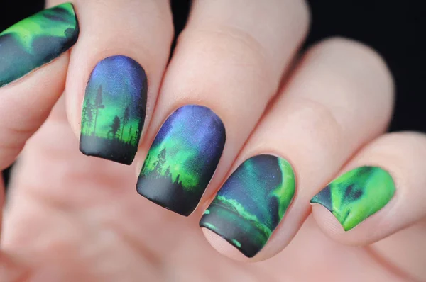 Manicure with northern lights print in blue and green 로열티 프리 스톡 이미지