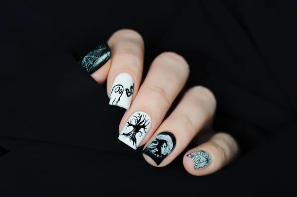 Black and white manicure on Halloween with tree, witch, moon, spider web and ghost BOO 로열티 프리 스톡 이미지