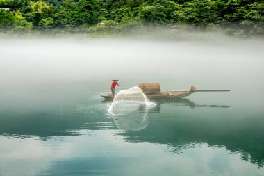 Misty küçük Dongjiang bir balıkçı