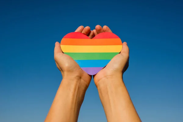 Kadın elinde gökkuşağının renginde bir kalp tutuyor. Genç, güzel bir kız. Lgbt tarihi ayı. Gurur Ayı. Lezbiyen Gey Biseksüel Transseksüel. Lgbt bayrağı. Aşk, insan hakları, hoşgörü. Lgbtq+