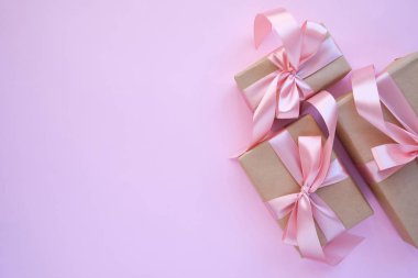 Pembe arka planda güzel bir hediye. Kurdeleli ve pembe kurdeleli hediye paketi. Noel için sürpriz, Sevgililer Günü veya Anneler Günü. İyi tatiller. Kutlama etkinliği. Hediye kutusu yakın plan