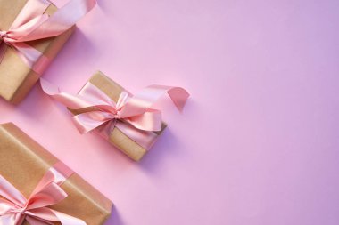 Pembe arka planda güzel bir hediye. Kurdeleli ve pembe kurdeleli hediye paketi. Noel için sürpriz, Sevgililer Günü veya Anneler Günü. İyi tatiller. Kutlama etkinliği. Hediye kutusu yakın plan