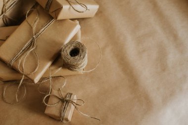 Hediye kutusu ambalajı. Kraft ambalaj kağıdı ve doğal sicim. Geri dönüşüm malzemesi. Mutlu bayramlar, sürpriz. Boks günü için hediyeler. Teslimat servisi, nakliye. El işi sanatları. Kutlama etkinliği