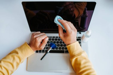 Laptop temizliği. Not defteri ekranı, klavye, çanta temizleme servisi. Temizlik aksesuarları: fırça, bez, sprey. Bilgisayar monitörü, dikkat et. Profesyonel hizmet, temizlik. Bilgisayarı silen adam