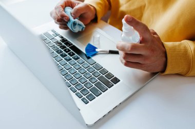 Laptop temizliği. Not defteri ekranı, klavye, çanta temizleme servisi. Temizlik aksesuarları: fırça, bez, sprey. Bilgisayar monitörü, dikkat et. Profesyonel hizmet, temizlik. Bilgisayarı silen adam