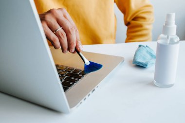 Laptop temizliği. Not defteri ekranı, klavye, çanta temizleme servisi. Temizlik aksesuarları: fırça, bez, sprey. Bilgisayar monitörü, dikkat et. Profesyonel hizmet, temizlik. Bilgisayarı silen adam