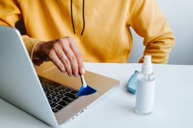 Laptop temizliği. Not defteri ekranı, klavye, çanta temizleme servisi. Temizlik aksesuarları: fırça, bez, sprey. Bilgisayar monitörü, dikkat et. Profesyonel hizmet, temizlik. Bilgisayarı silen adam