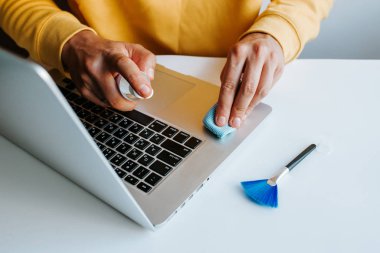 Laptop temizliği. Not defteri ekranı, klavye, çanta temizleme servisi. Temizlik aksesuarları: fırça, bez, sprey. Bilgisayar monitörü, dikkat et. Profesyonel hizmet, temizlik. Bilgisayarı silen adam