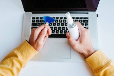 Laptop temizliği. Not defteri ekranı, klavye, çanta temizleme servisi. Temizlik aksesuarları: fırça, bez, sprey. Bilgisayar monitörü, dikkat et. Profesyonel hizmet, temizlik. Bilgisayarı silen adam