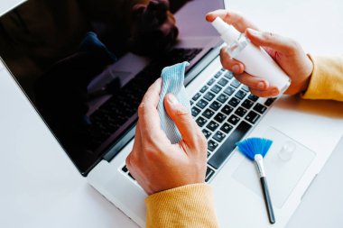 Laptop temizliği. Not defteri ekranı, klavye, çanta temizleme servisi. Temizlik aksesuarları: fırça, bez, sprey. Bilgisayar monitörü, dikkat et. Profesyonel hizmet, temizlik. Bilgisayarı silen adam
