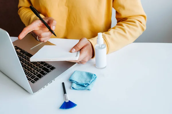 Laptop cleaning up. Service for cleaning notebook screen, keyboard, case. Cleaning accessories: brush, cloth, spray. Computer monitor, display care. Professional service, clean up. Man who wipe laptop