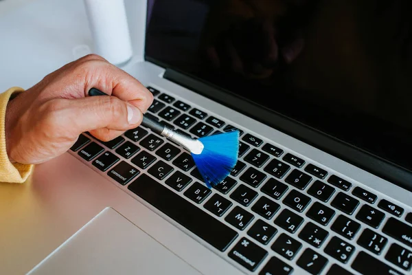 Laptop cleaning up. Service for cleaning notebook screen, keyboard, case. Cleaning accessories: brush, cloth, spray. Computer monitor, display care. Professional service, clean up. Man who wipe laptop