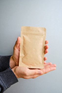 Kraft paper packaging in a mans hands. Packaging for coffee, cosmetics. Packing closeup. Product for sale. Online shopping. Boxes with surprise. Delivery service, shipping. Empty, mockup. Eco friendly