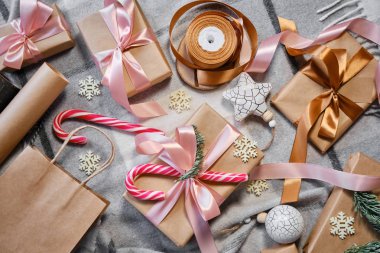 Noel hediyeleri masanın üstünde. Mutlu tatiller, hediye kutusu yakın çekimi. Boks günü, Noel ve yeni yıl partisi için sürpriz. Sihir zamanı. Kış kutlamaları. Paket kağıdı, oyuncaklar ve kurdele