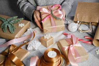 Kadın elinde bir Noel hediyesi tutuyor. Mutlu tatiller, hediye kutusu yakın çekimi. Boks günü, Noel ve yeni yıl partisi için sürpriz. Sihir zamanı. Kış kutlamaları. Paket kağıdı, oyuncaklar ve kurdele