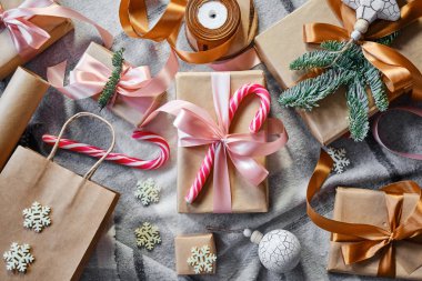 Noel hediyeleri masanın üstünde. Mutlu tatiller, hediye kutusu yakın çekimi. Boks günü, Noel ve yeni yıl partisi için sürpriz. Sihir zamanı. Kış kutlamaları. Paket kağıdı, oyuncaklar ve kurdele