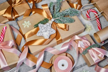 Noel hediyeleri masanın üstünde. Mutlu tatiller, hediye kutusu yakın çekimi. Boks günü, Noel ve yeni yıl partisi için sürpriz. Sihir zamanı. Kış kutlamaları. Paket kağıdı, oyuncaklar ve kurdele