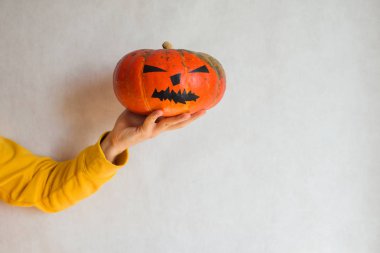 Cadılar Bayramı balkabağı. Elinde korkunç bir yüz kabağı tutan bir adam. Cadılar Bayramı partiniz kutlu olsun. Yıllığı 31 Ekim 'de kutlayın. Sonbahar sezonu. Sonbahar rengi, turuncu ve sarı. Şeker mi şaka mı? Balkabağı Günü