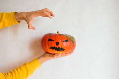 Cadılar Bayramı balkabağı. Elinde korkunç bir yüz kabağı tutan bir adam. Cadılar Bayramı partiniz kutlu olsun. Yıllığı 31 Ekim 'de kutlayın. Sonbahar sezonu. Sonbahar rengi, turuncu ve sarı. Şeker mi şaka mı? Balkabağı Günü