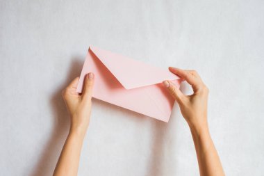 Kadın el kâğıdı zarfını tutuyor. Yeni posta, mesaj. Posta servisi. Genç kız mektup göndermek ya da almak istiyor. Boş zarf, boş alan. İnsanlar iletişim konsepti. Zarf maketi yakın plan