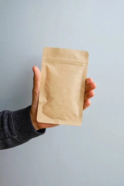 Kraft paper packaging in a mans hands. Packaging for coffee, cosmetics. Packing closeup. Product for sale. Online shopping. Boxes with surprise. Delivery service, shipping. Empty, mockup. Eco friendly