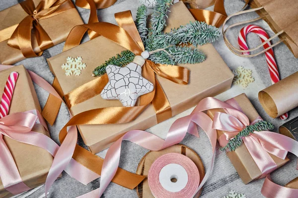 Noel hediyeleri masanın üstünde. Mutlu tatiller, hediye kutusu yakın çekimi. Boks günü, Noel ve yeni yıl partisi için sürpriz. Sihir zamanı. Kış kutlamaları. Paket kağıdı, oyuncaklar ve kurdele