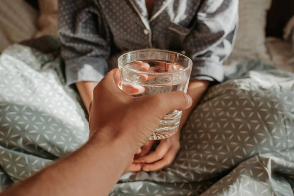 躺在床上手里拿着一杯水的女人 早晨快乐 穿睡衣的女孩 健康的生活 健康的生活 适当的营养 饮用水 早上与水 亚麻布上的阳光 — 图库照片
