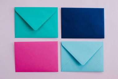 Colored paper envelopes on a light background. New mail, write message. Send and receive letter. Postal delivery service. Blank envelope, empty space. People communication, paperwork. Envelope closeup