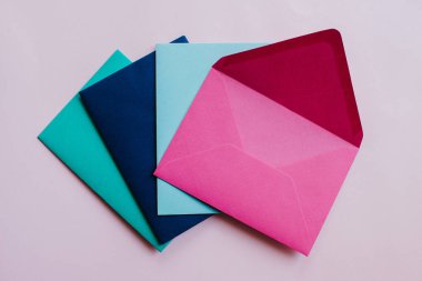 Colored paper envelopes on a light background. New mail, write message. Send and receive letter. Postal delivery service. Blank envelope, empty space. People communication, paperwork. Envelope closeup