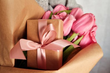 Mutlu kadın laleleri elinde tutuyor. Çiçekçi kız bir buket topladı. Güzel pembe çiçekler. Çiçek yaprağı. Bayram kutlaması için bir hediye, bahar havası. Sevdiğin birinden romantik bir sürpriz.