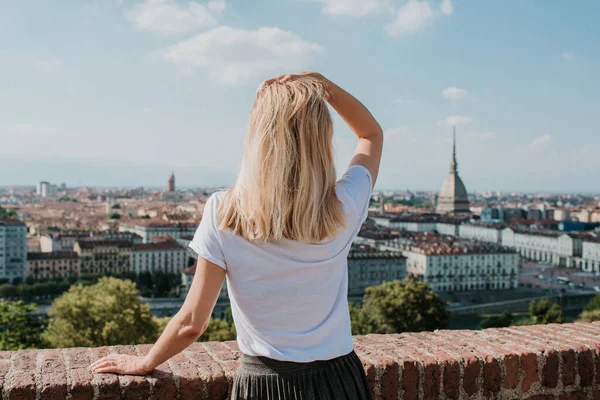 Sarışın kadın Torino 'nun manzarasının tadını çıkarıyor. Köstebek Antonelliana 'nın muhteşem manzarası. Kız Piemonte, İtalya 'yı keşfediyor. Kasaba ve dağ. Şehir manzarası, eski tarihi mimari. Seyahat, macera, yaşam tarzı