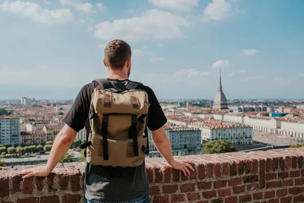 Sırt çantalı adam Torino manzarasının tadını çıkarıyor. Köstebek Antonelliana 'nın muhteşem manzarası. Piemonte, İtalya 'yı keşfedin. Kasaba ve dağ. Şehir manzarası, eski tarihi mimari. Seyahat, macera, yaşam tarzı