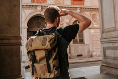 Sırt çantalı bir adam şehrin sokaklarında yürüyor. Turistler Avrupa 'da tatilin tadını çıkarırlar. Güzel eski tarihi mimari. İtalyan hafta sonu. Torino, İtalya 'ya git. Macera yaşam tarzı